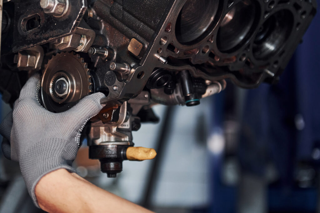 auto mechanic inspecting engine components during preventative maintenance to prevent costly repairs and improve vehicle reliability