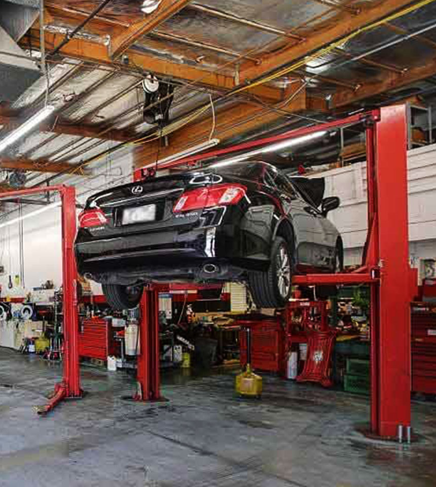 Vehicle on lift inside Airpark Auto Clinic, showcasing professional auto repair services and well-equipped service bays.