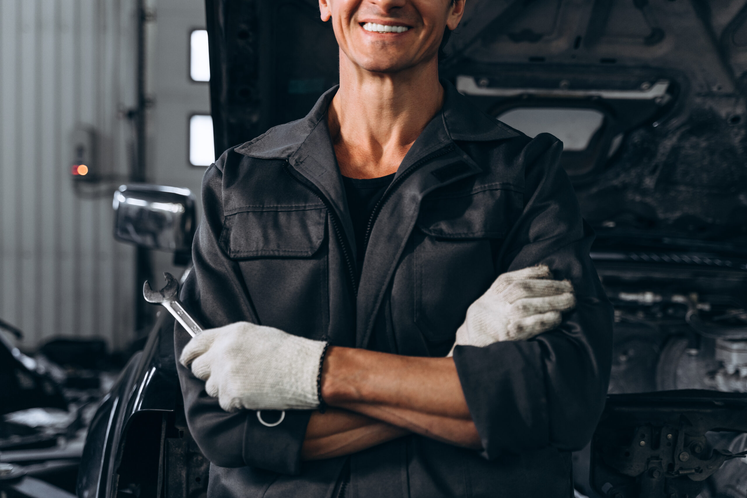 Auto technician standing in front of an open vehicle hood, representing professional cooling system maintenance and radiator service at Airpark Auto Clinic in Scottsdale.